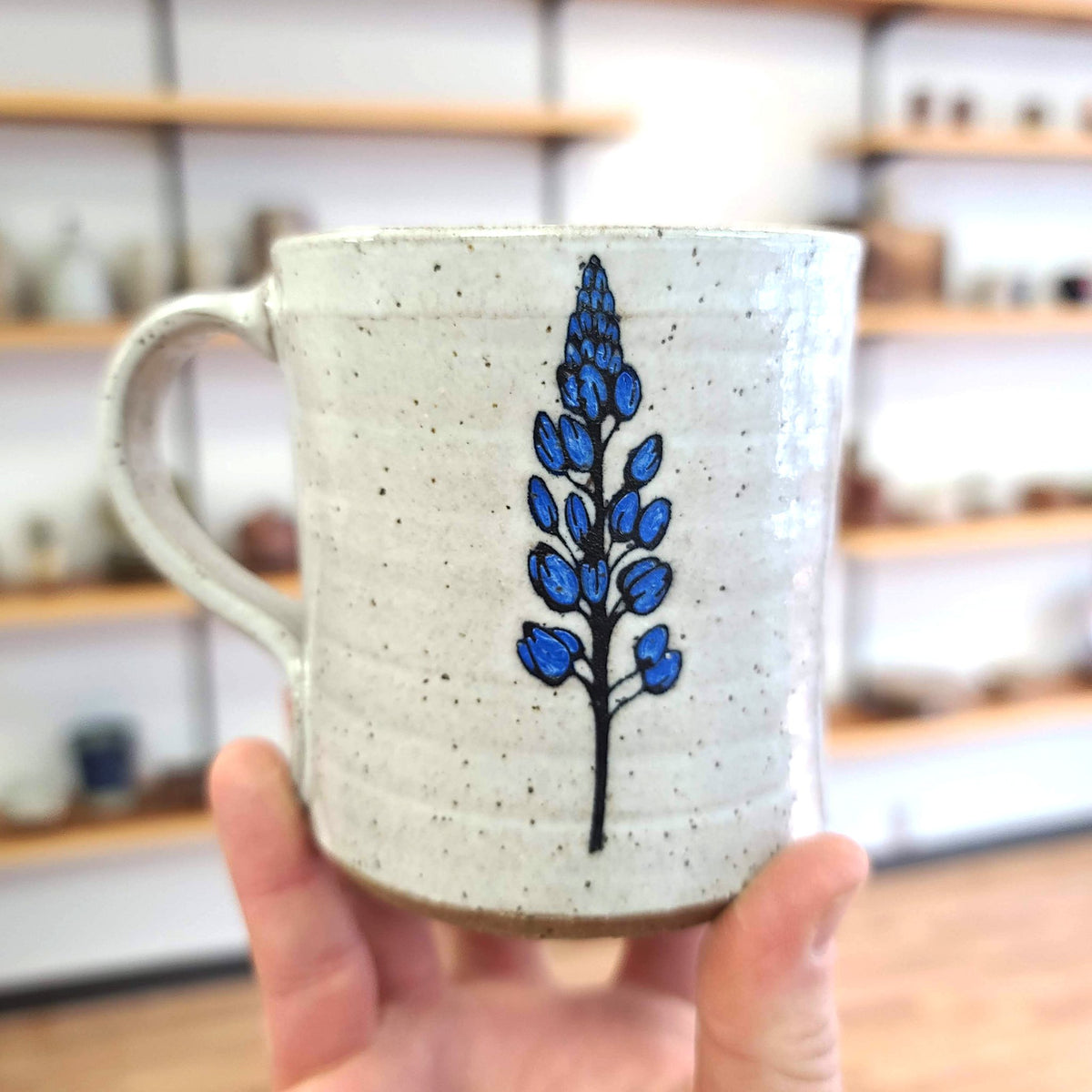 15oz Ceramic Mug featuring a blue lupine flower on nuetral cream glaze